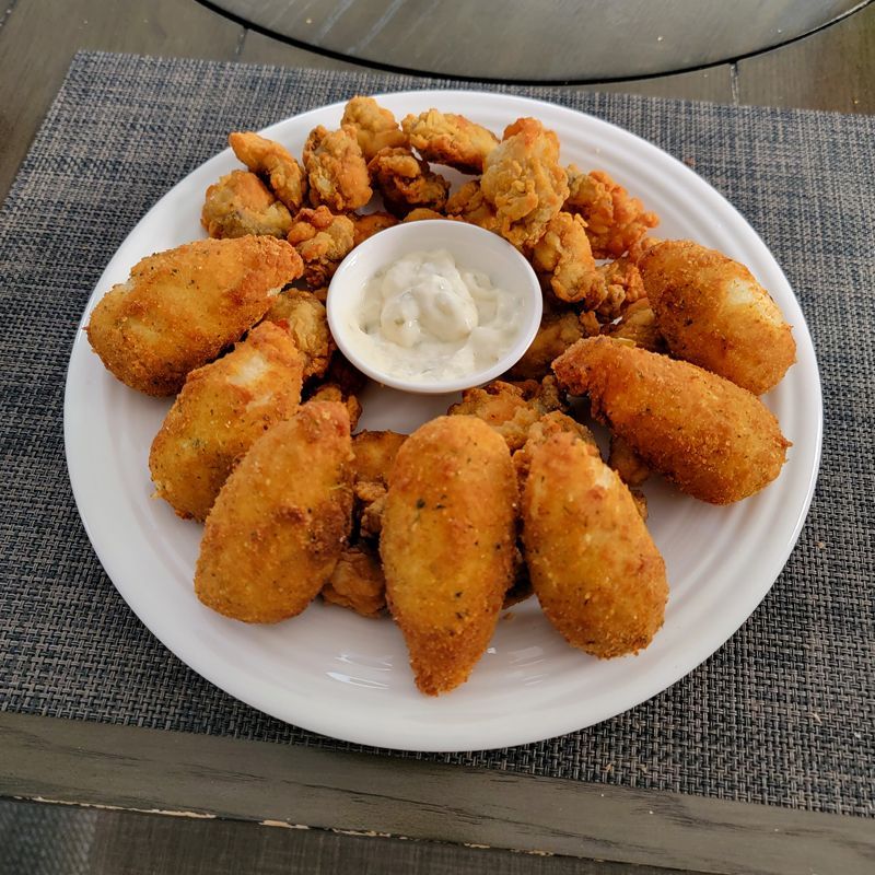 A white plate topped with fried food and a small bowl of ranch dressing