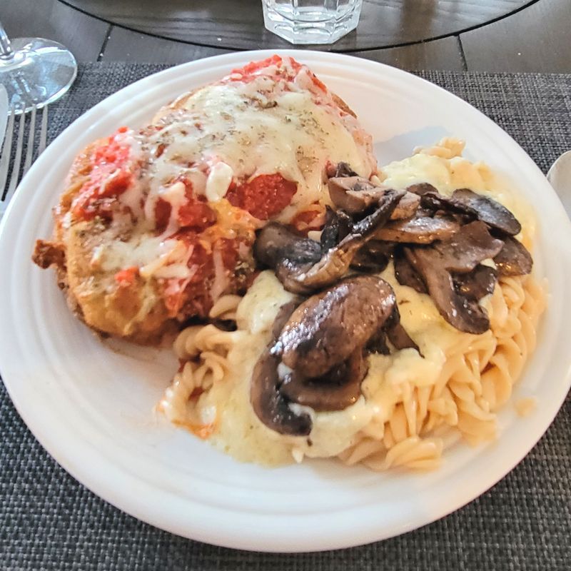 A plate of food with mushrooms and noodles on a table