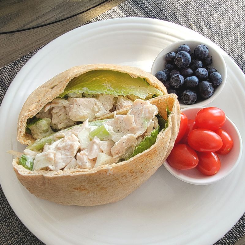 A pita sandwich with blueberries and tomatoes on a plate