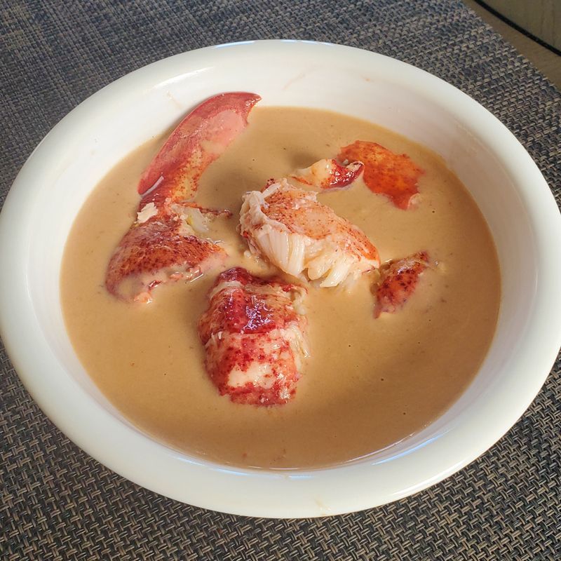 A bowl of lobster bisque it on a table