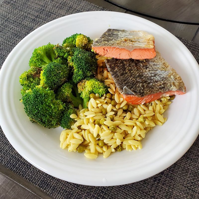 A white plate topped with broccoli rice and wild salmon fillets