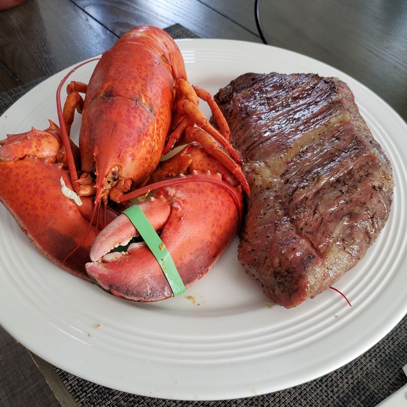 A plate of lobster and steak on a table