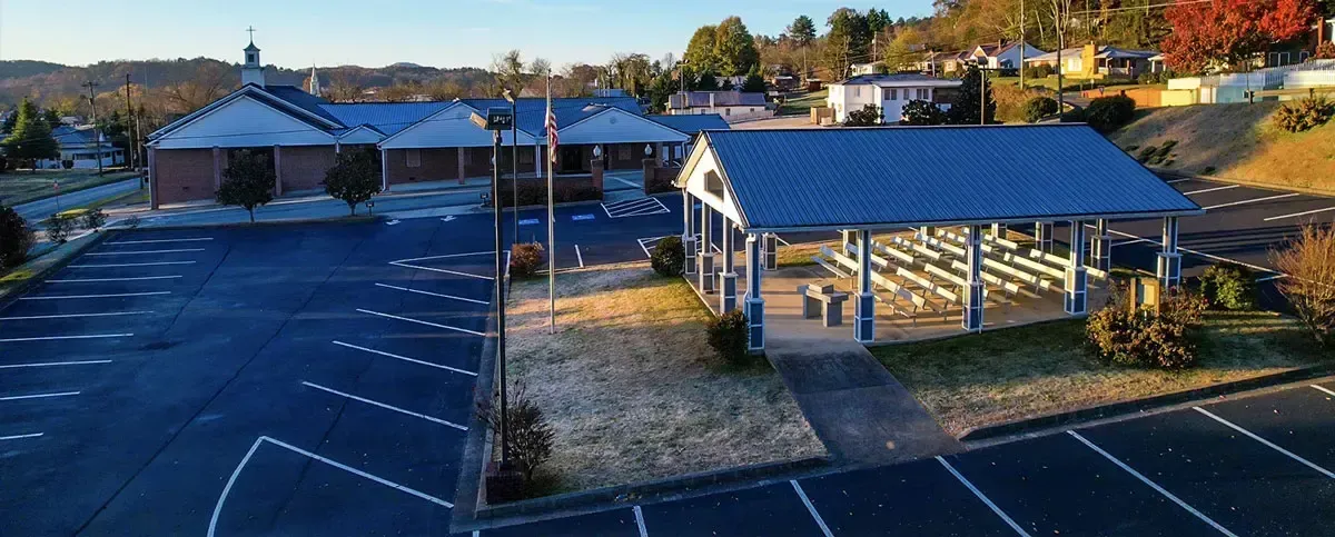 Aerial view of a parking lot and a building with a blue roof at dusk