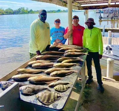 A group of men are standing around a table filled with fish.