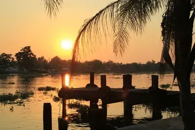 A sunset over a body of water with a dock in the foreground