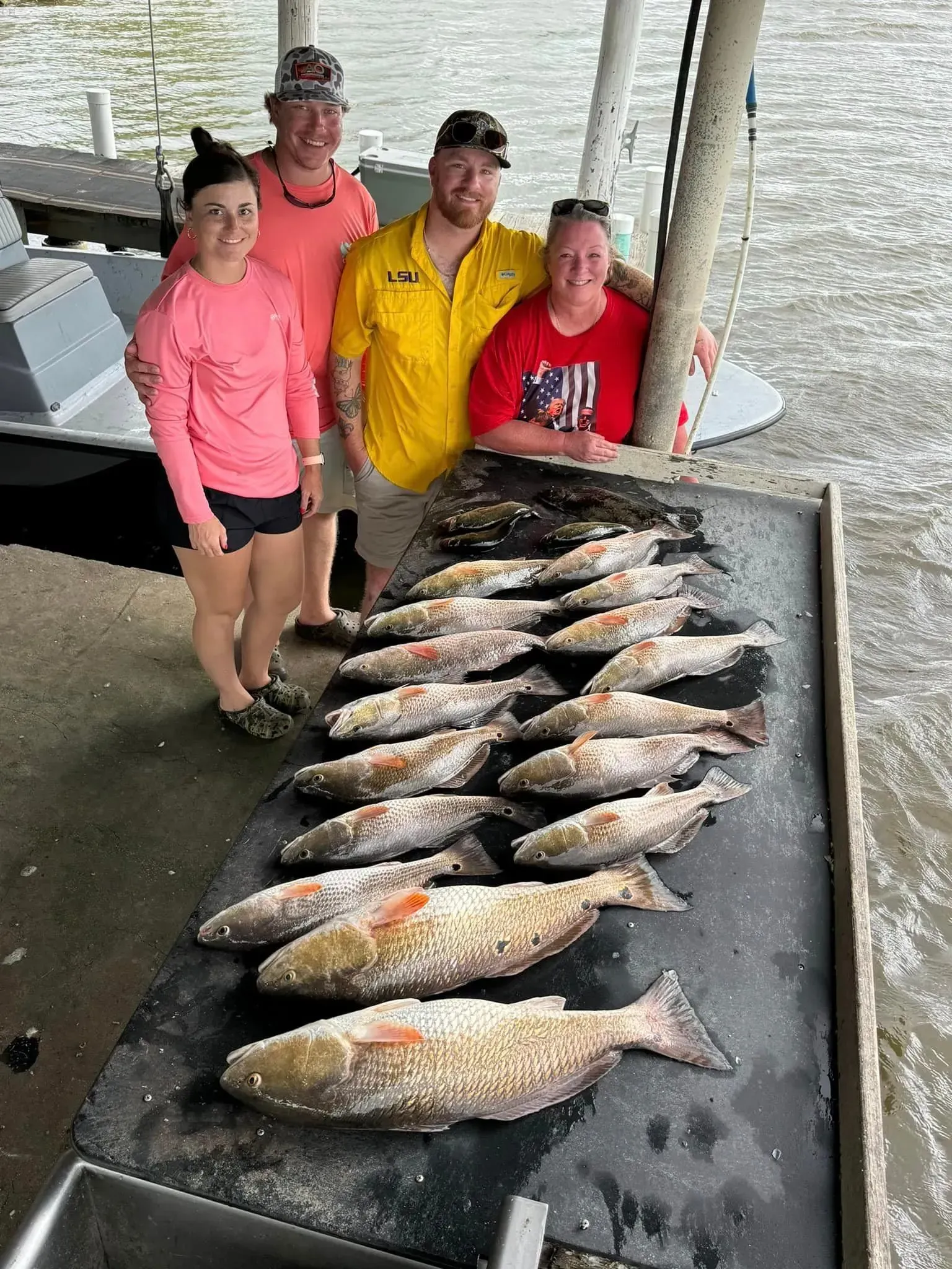 A group of people are standing around a table filled with fish.