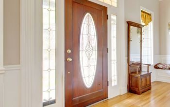 A hallway with a wooden door and stained glass windows.