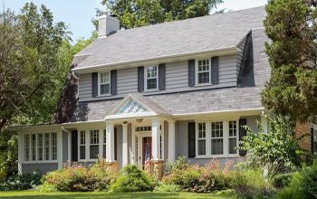 A large white house with a gray roof and black shutters