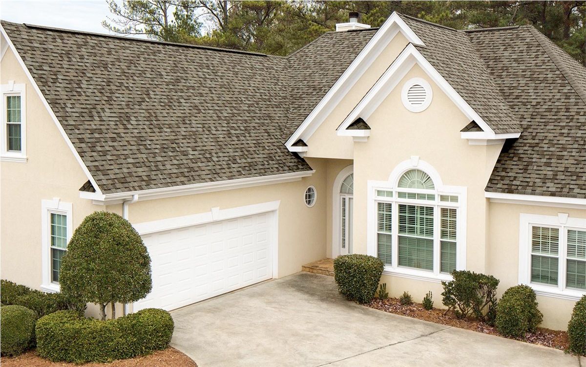 A house with a garage and a driveway in front of it.