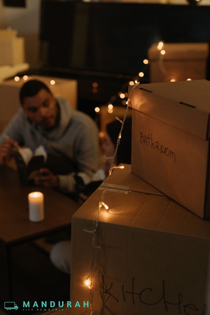 A family sitting together surrounded by moving boxes