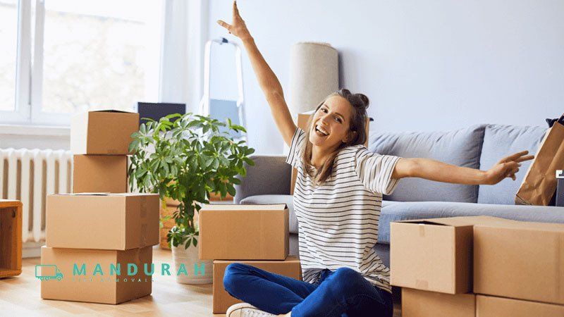 A smiling girl surrounded by moving boxes