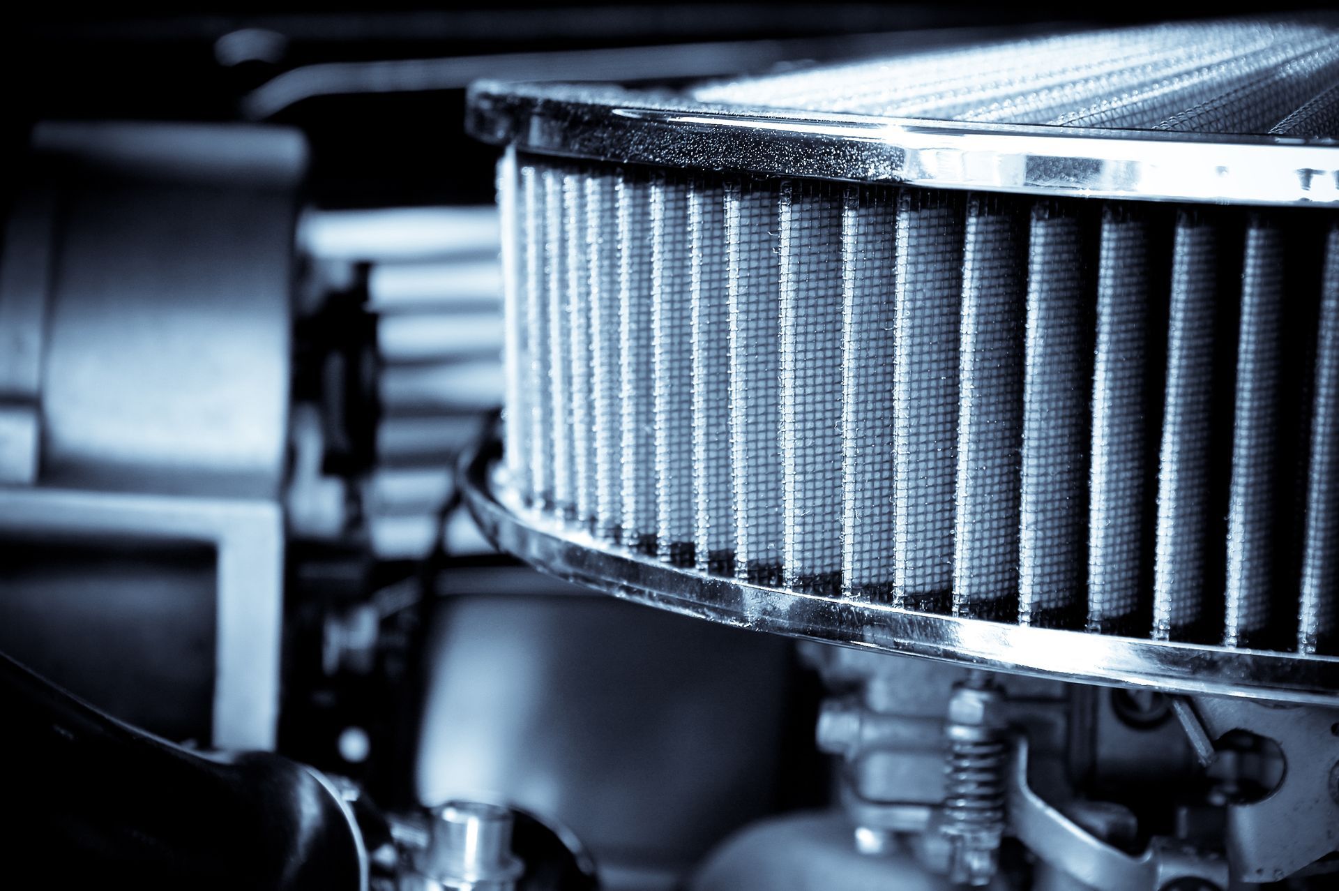 Close-up of a classic car engine with a shiny chrome air filter.