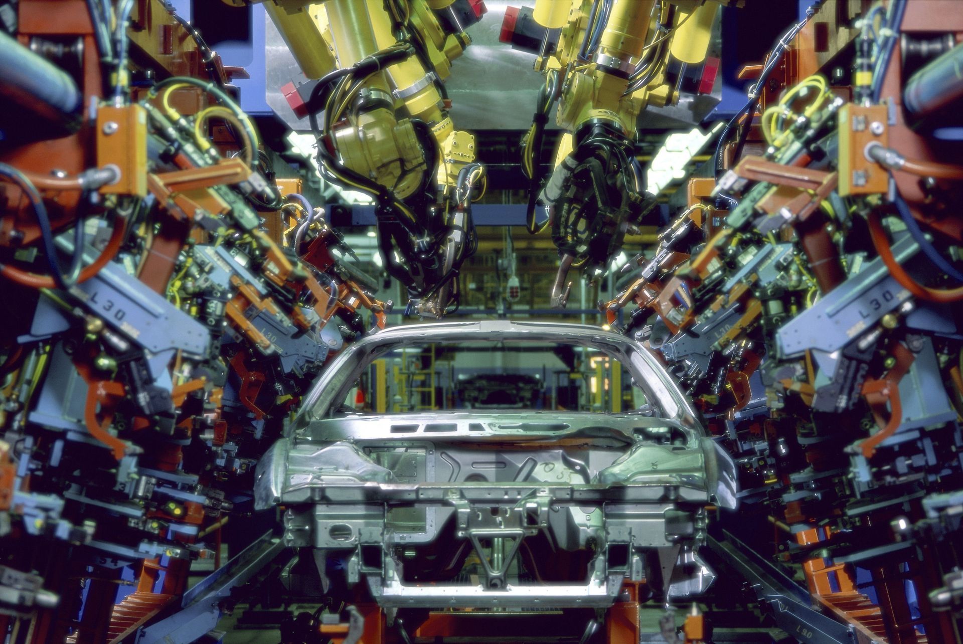 Robots welding a car frame on an automotive assembly line.