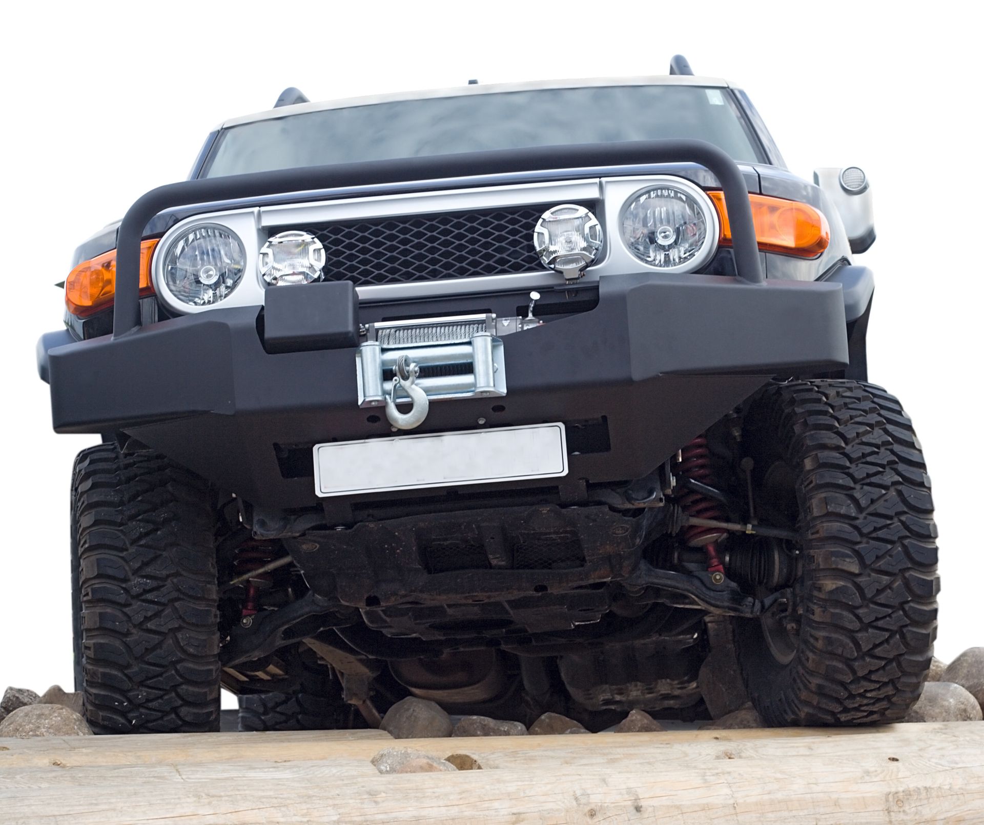 Gray off-road vehicle with large tires on a rough terrain.