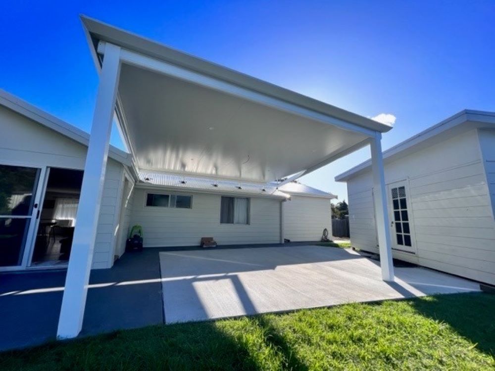 A White House With a Covered Driveway in Front of It — Outdoor Leisure Living In Tuggerah, NSW