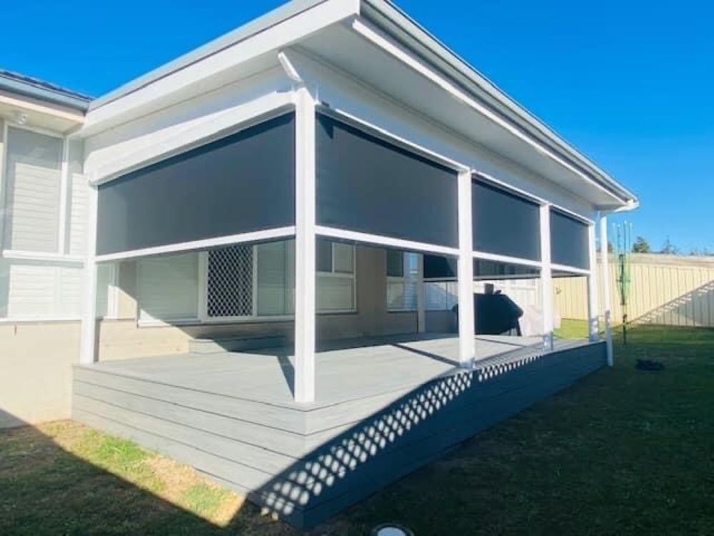 A White House With a Porch With Black Blinds on It — Outdoor Leisure Living In Tuggerah, NSW