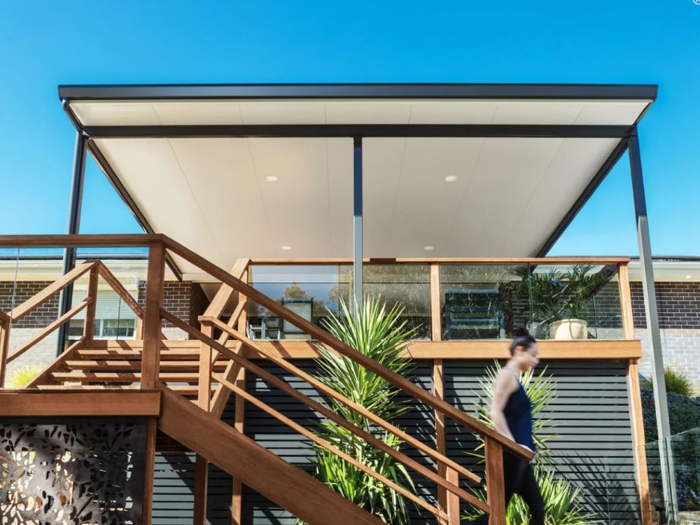 A Woman is Walking Down the Stairs of a House — Outdoor Leisure Living In Tuggerah, NSW