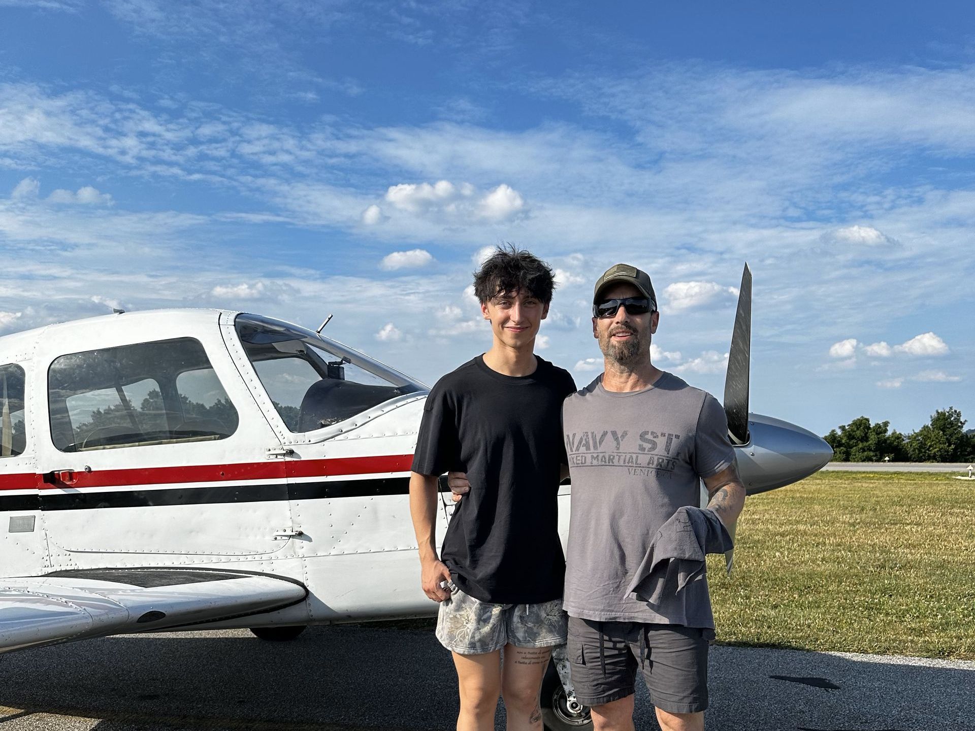 Four men standing in front of a monster truck