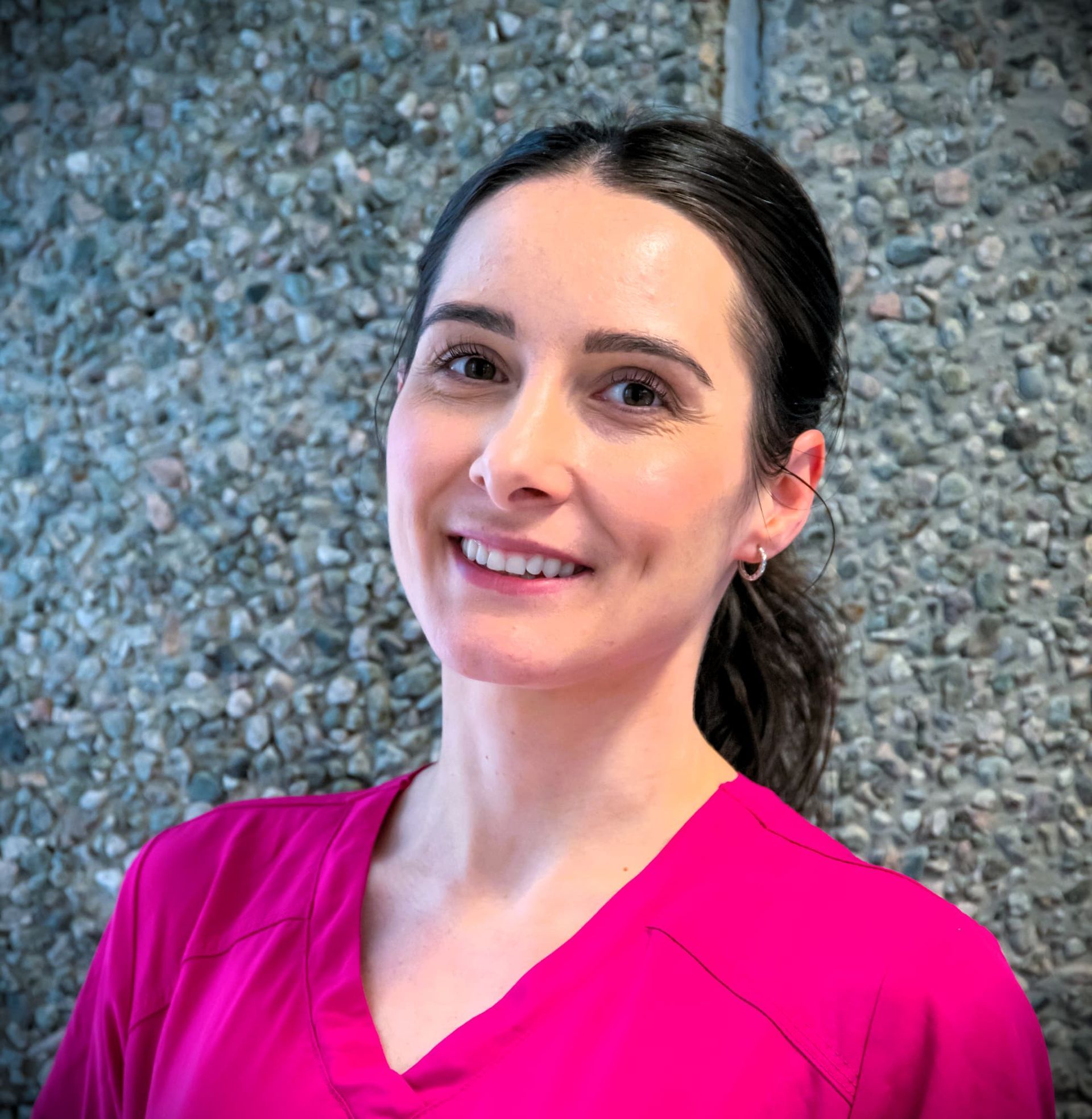 Tannlege Christian med briller og skjegg, iført blå skjorte og medisinsk maske, smiler til kameraet.