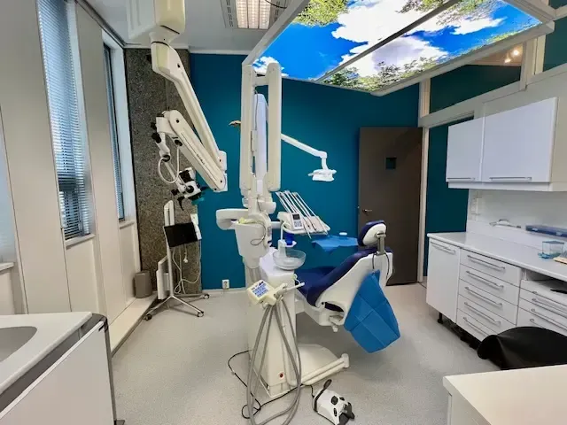 Seks kvinner i skrubber smiler i lyse omgivelser innendørs.