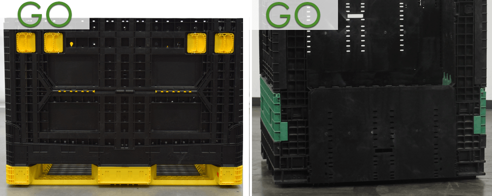 A black plastic crate is sitting on top of a yellow pallet.