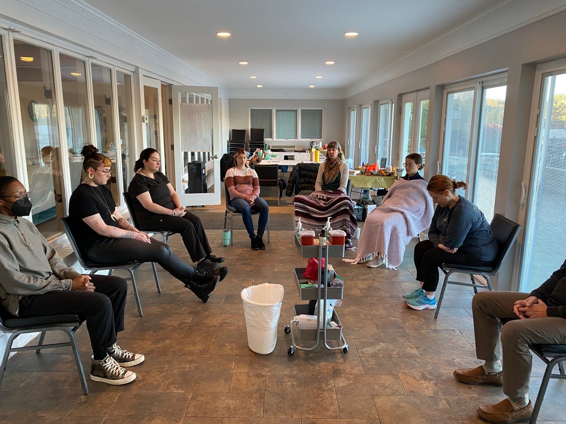 A group of people are sitting in a circle in a room.