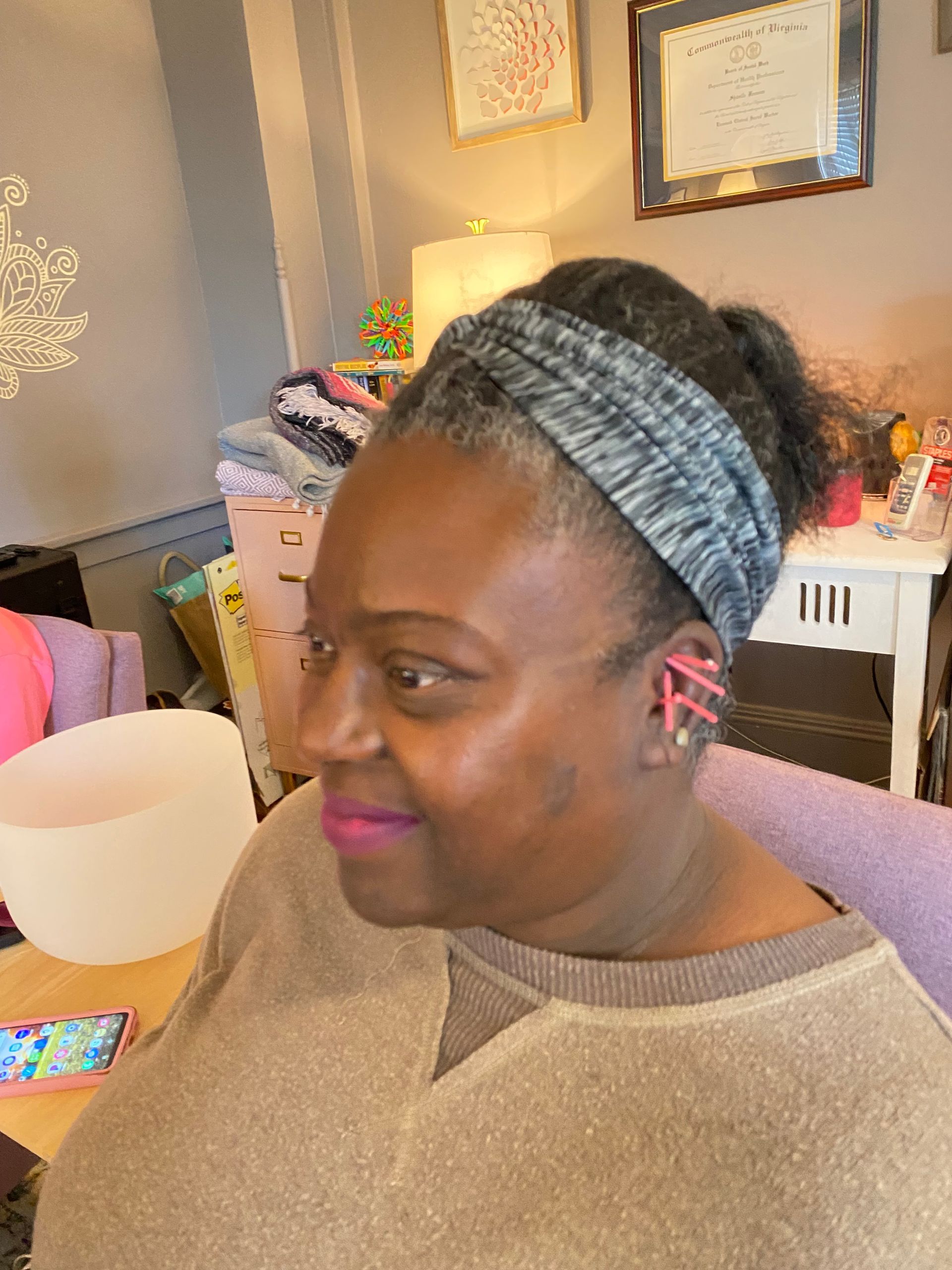 A woman wearing a headband is sitting in a chair in a living room.