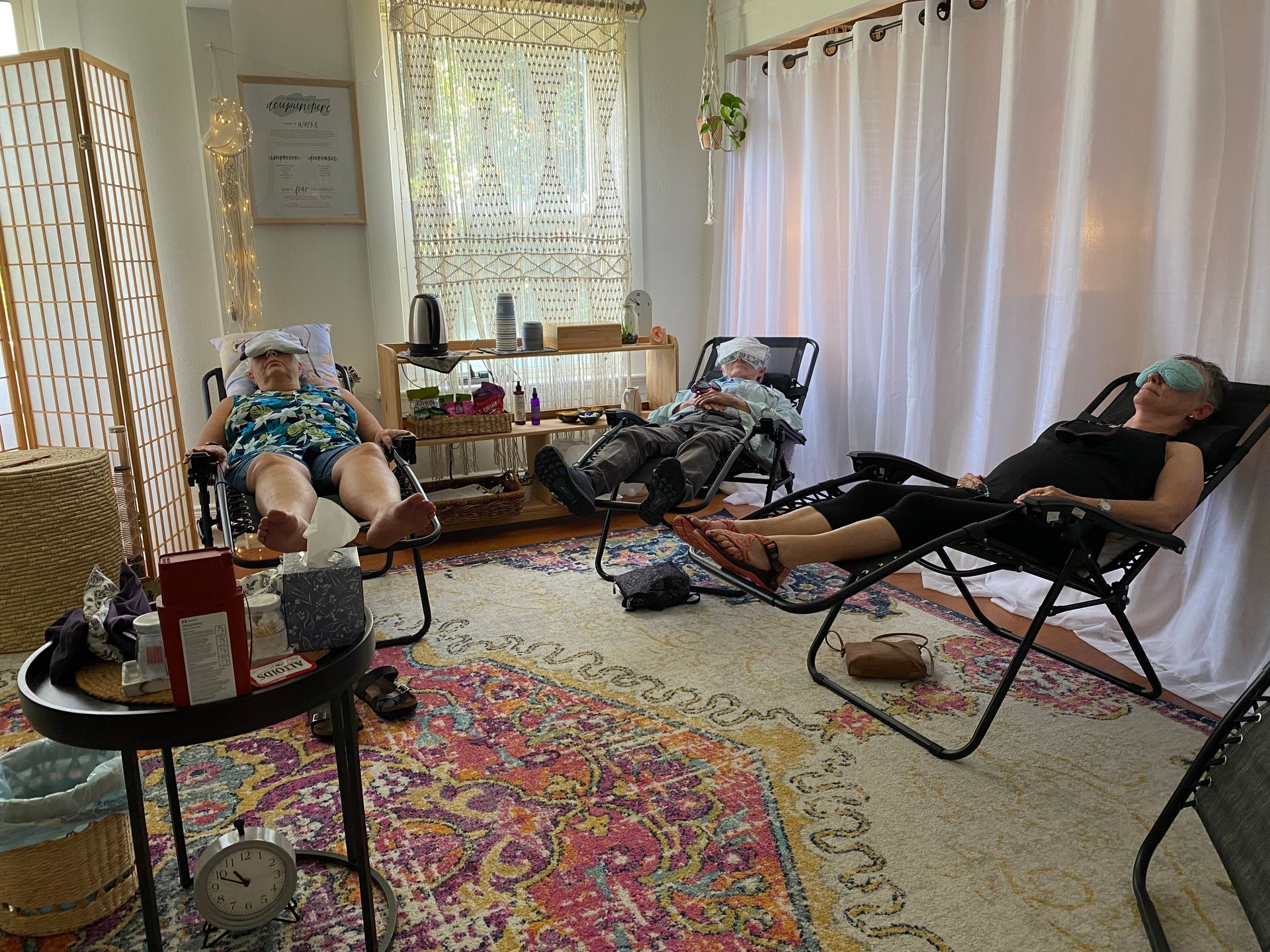 A group of people are sitting in chairs in a living room.