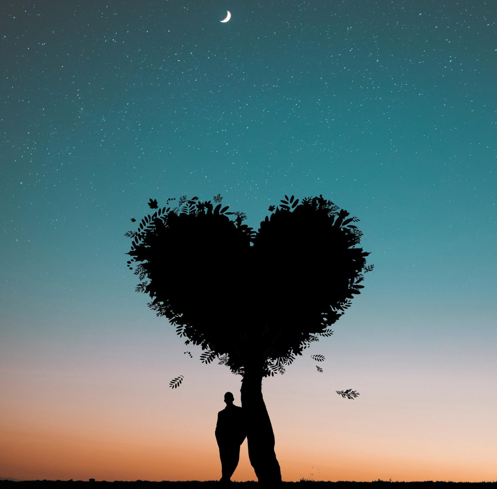 A couple standing under a heart shaped tree