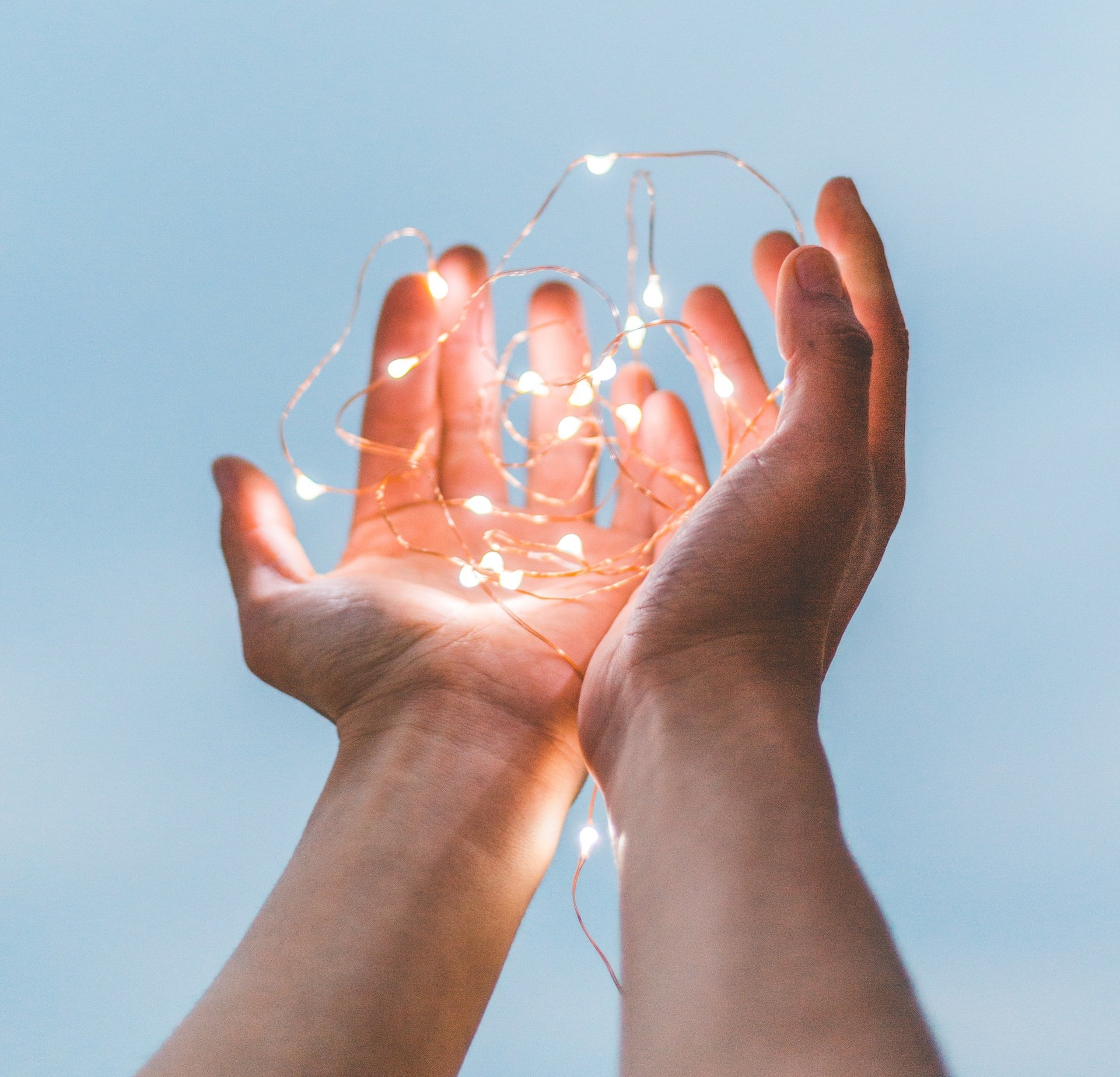 A person is holding a string of lights in their hands.