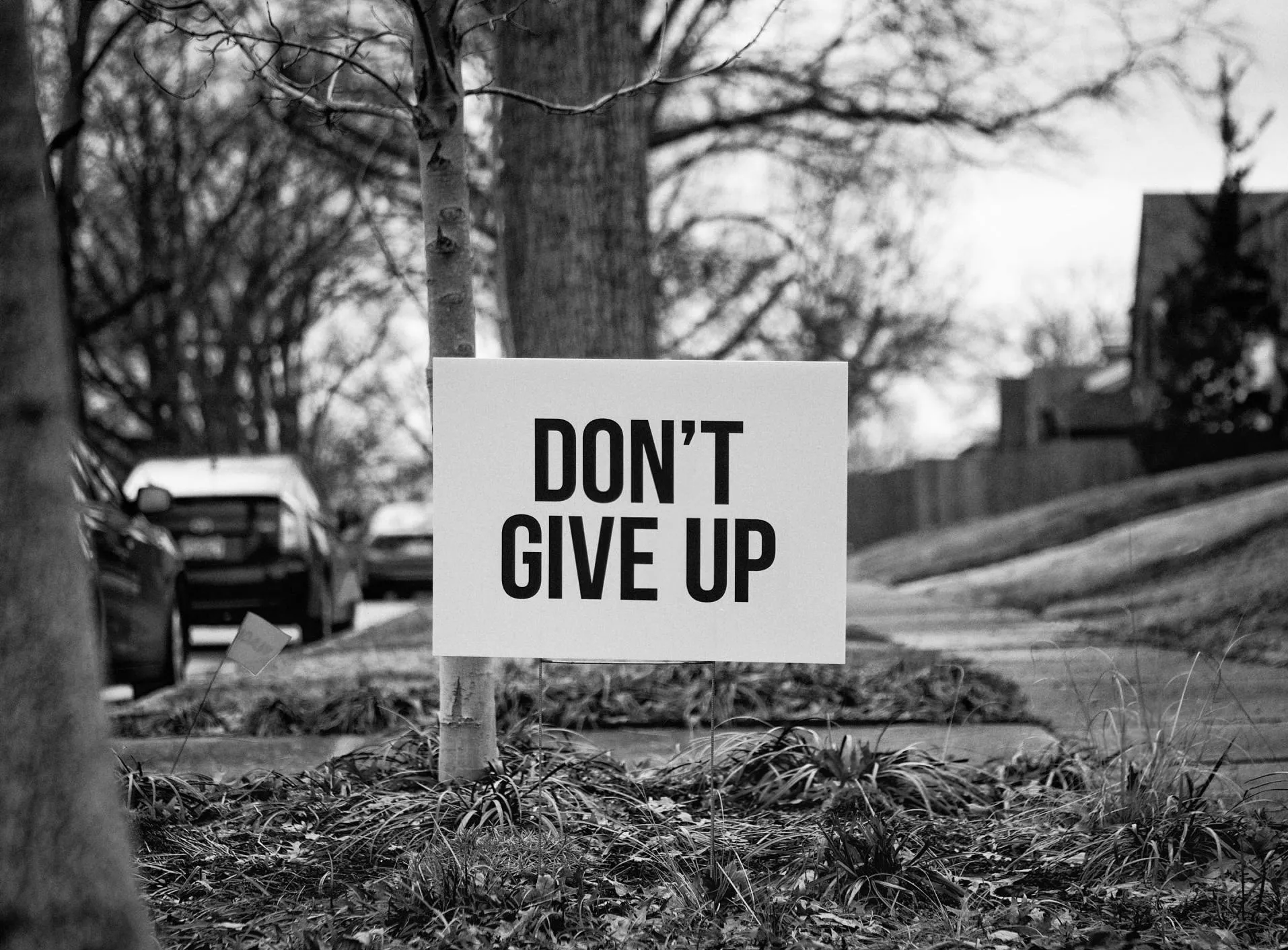 A black and white photo of a sign that says `` do n't give up ''.