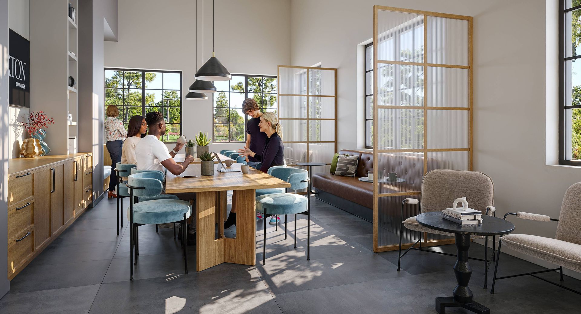 A modern office interior with people around a table, a lounge area, and a glass partition.