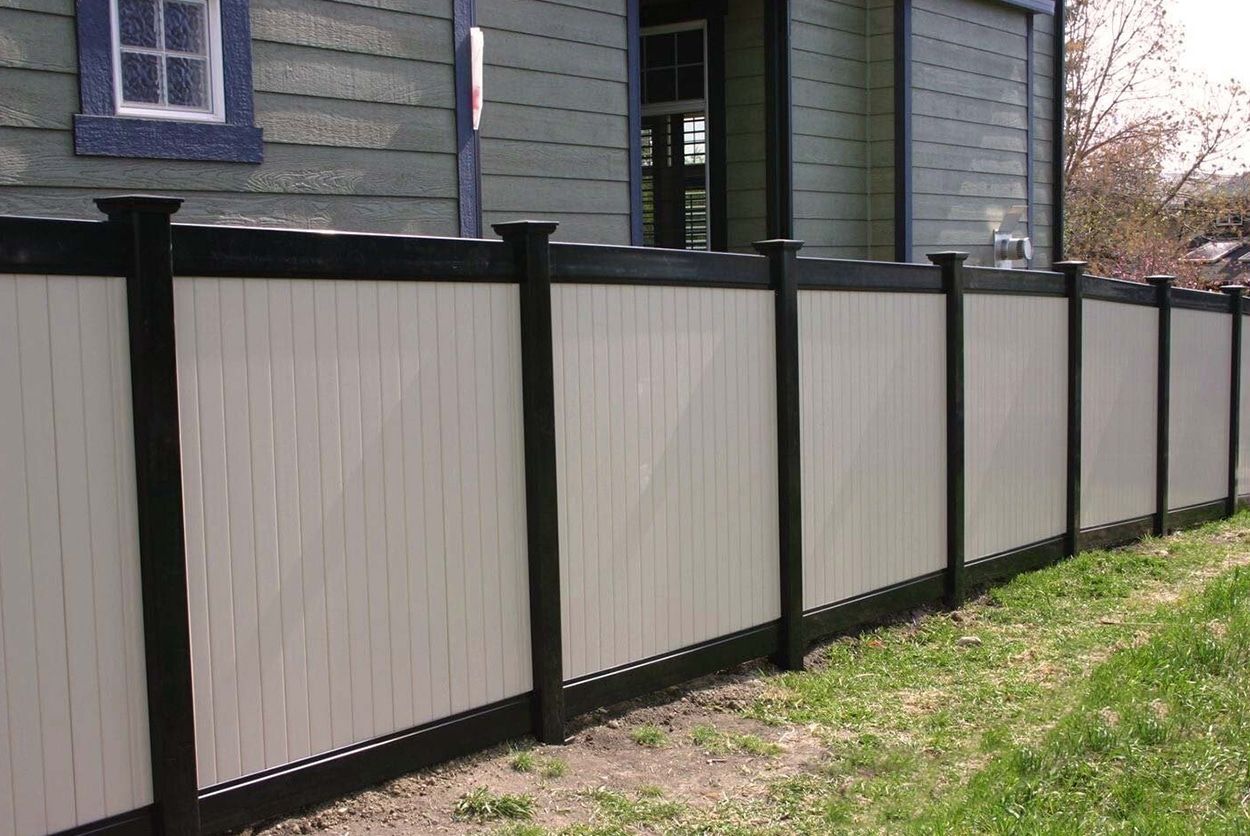 A black and white fence is in front of a house.