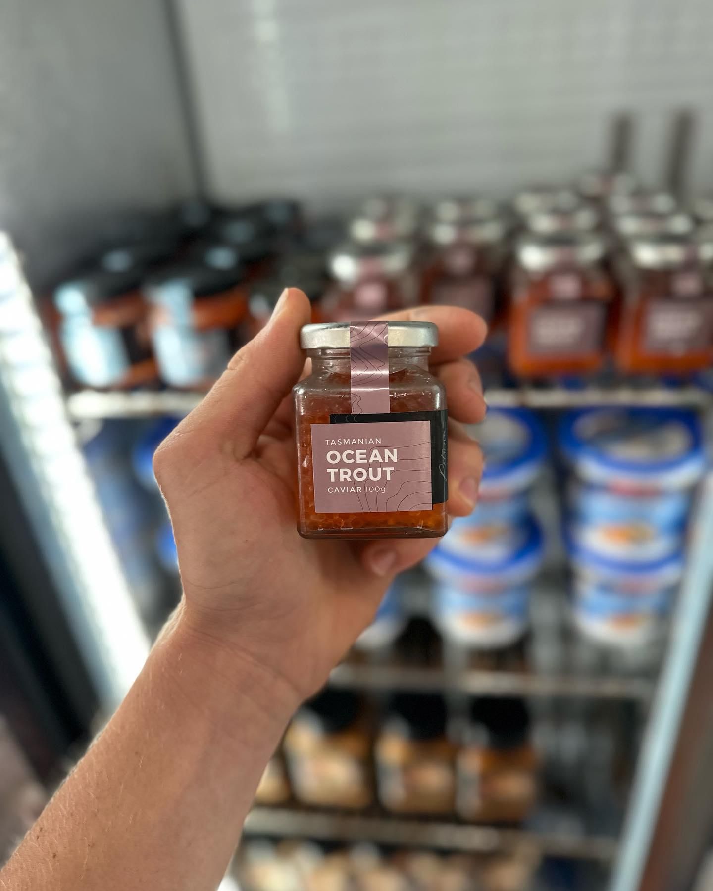 A Person Is Holding A Jar Of Sauce In Front Of A Refrigerator — Northern Rivers Seafood In Ballina, NSW