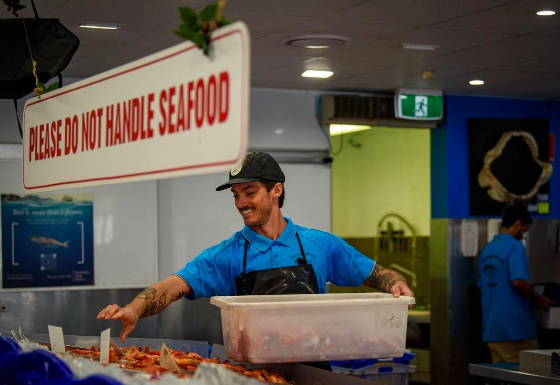 Man Stocking Prawn Container Up — Northern Rivers Seafood In Ballina, NSW