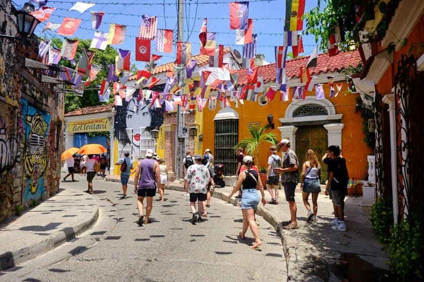 Escena callejera en Cartagena, Colombia, con edificios coloridos y banderas ondeando.  | Mevak Agency