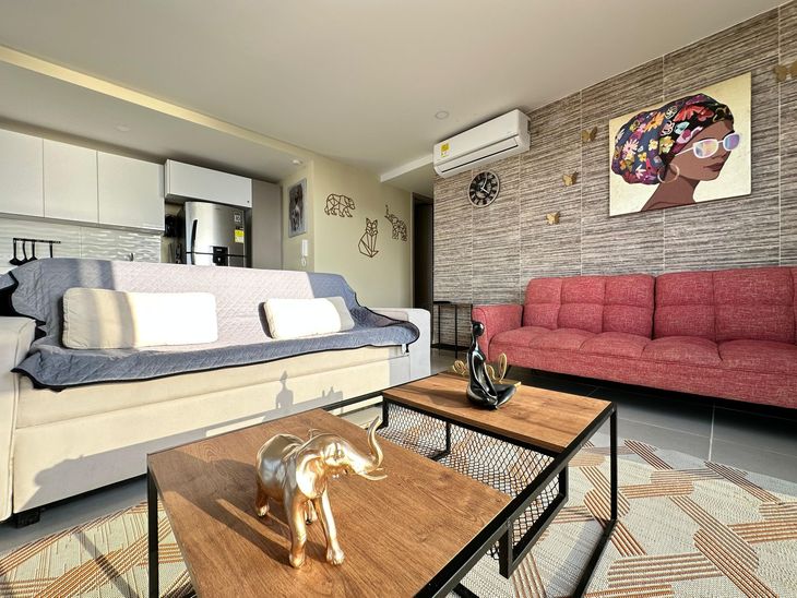 Sala de estar con dos mesas de café, sofás y una decoración de pared  | Mevak Agency