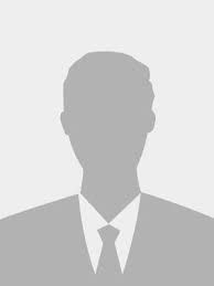 Persona sonriente con traje y corbata, sobre un fondo claro.  | Mevak Agency