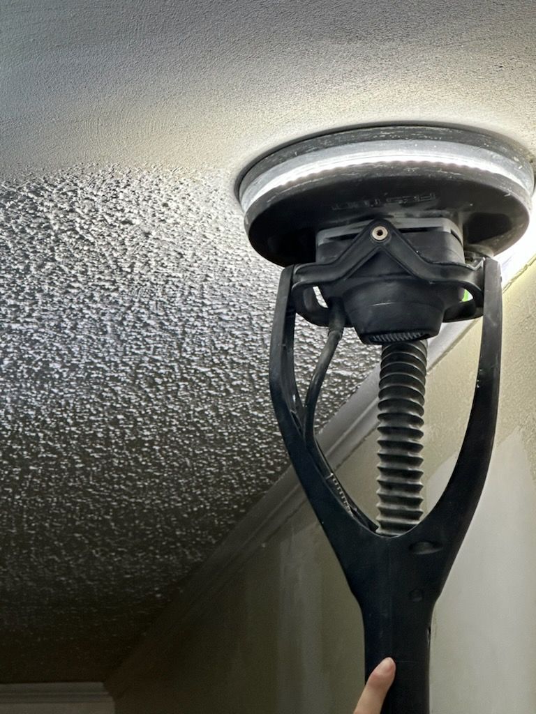 A person is holding a lamp that is hanging from the ceiling.