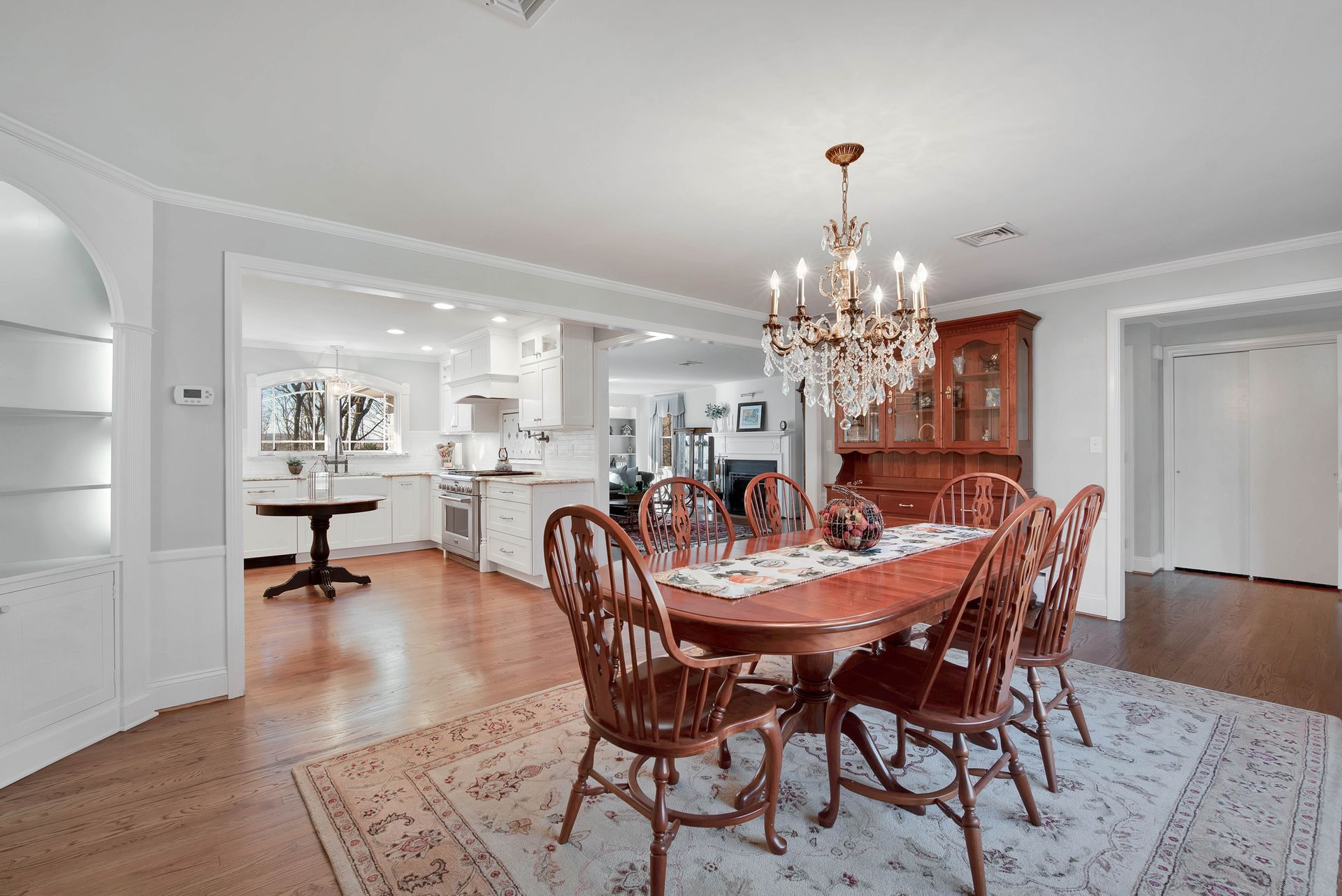 Dining room with table, chairs, chandelier, and a view into the kitchen.