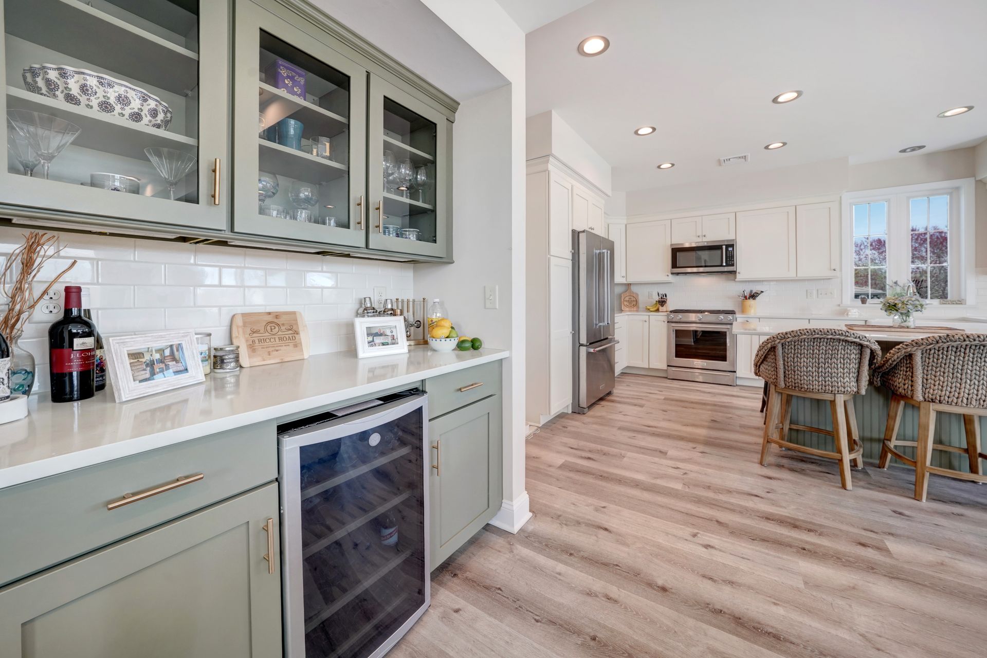 Kitchen with sage green cabinets, white countertops, and stainless steel appliances.