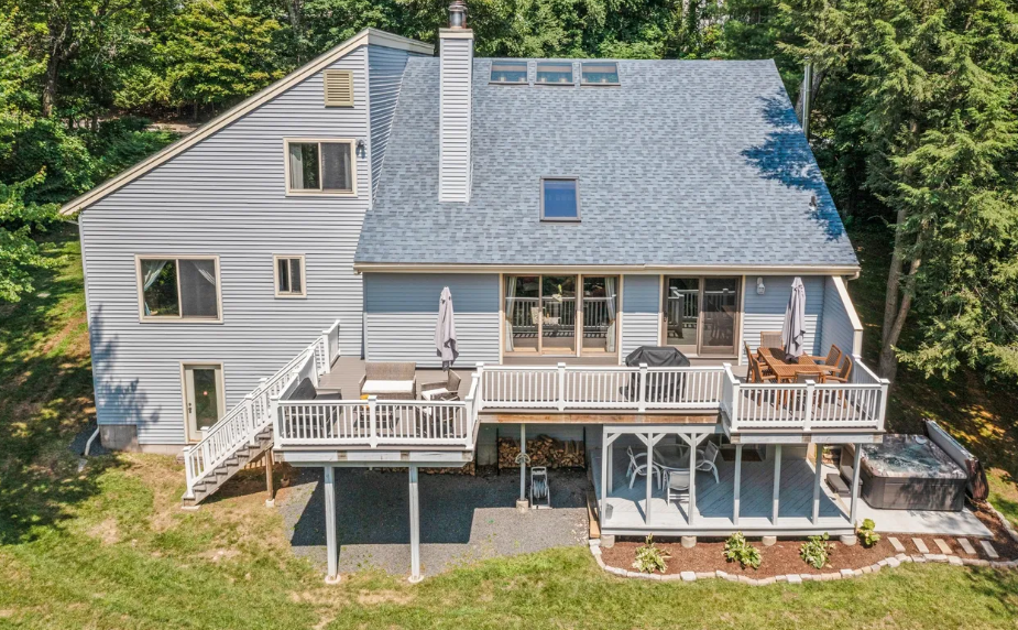Blue house with decks, surrounded by greenery.