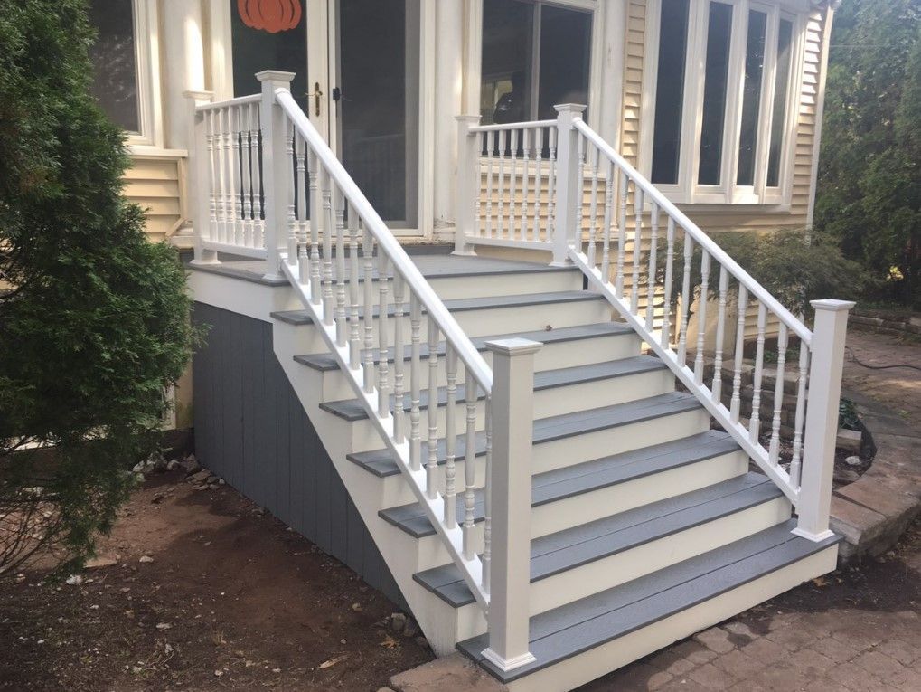 White and gray deck stairs leading to a porch with white railing.