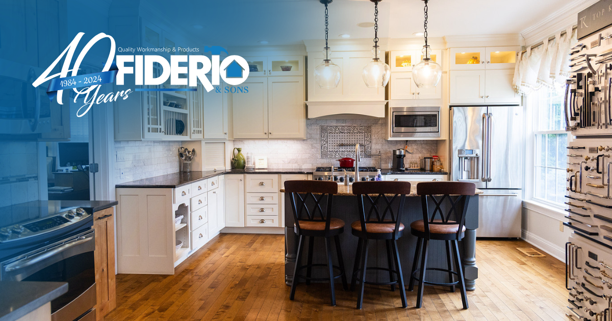 A white kitchen with a dark center island, three bar stools, and a branded 