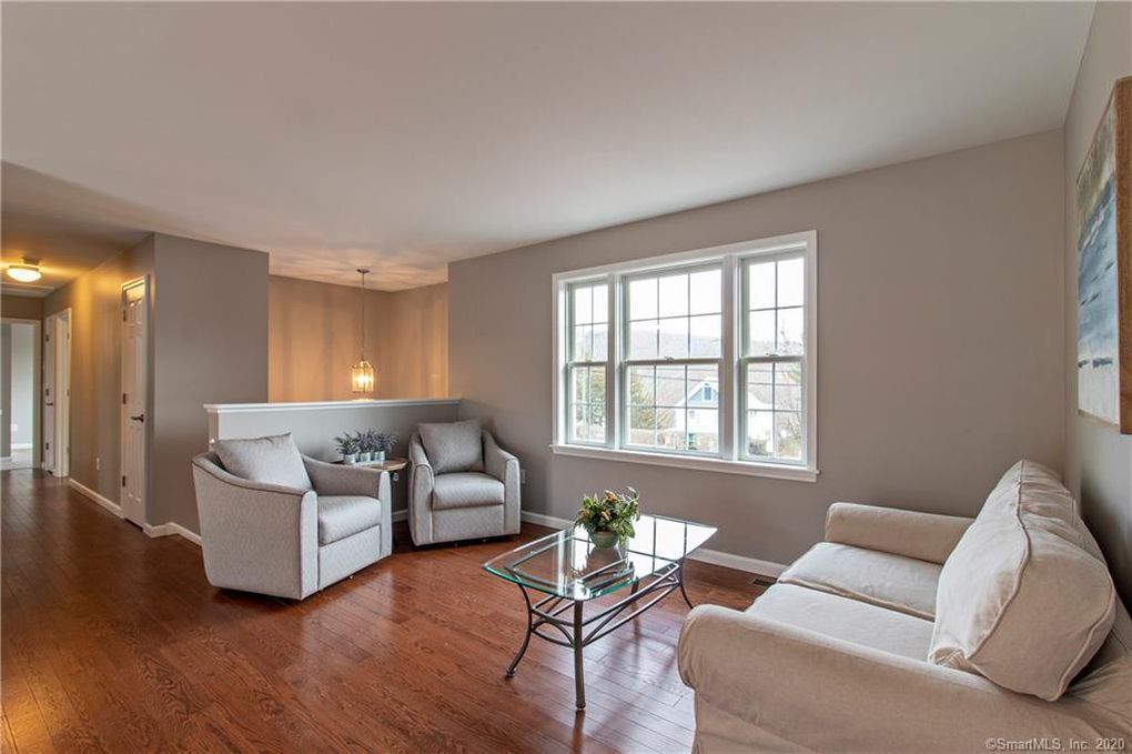 Living room with two armchairs, a sofa, coffee table, window, and hardwood floors.
