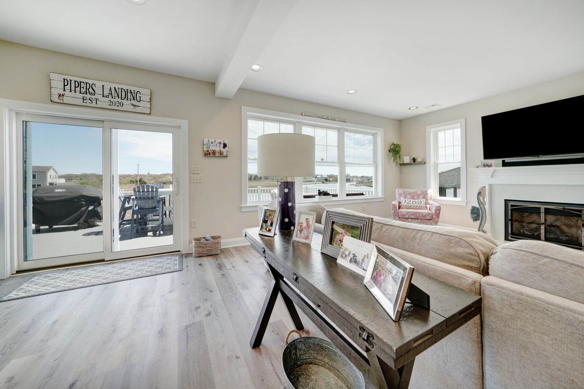 Bright living room with water view, sliding door, neutral colors, fireplace, and sofa.