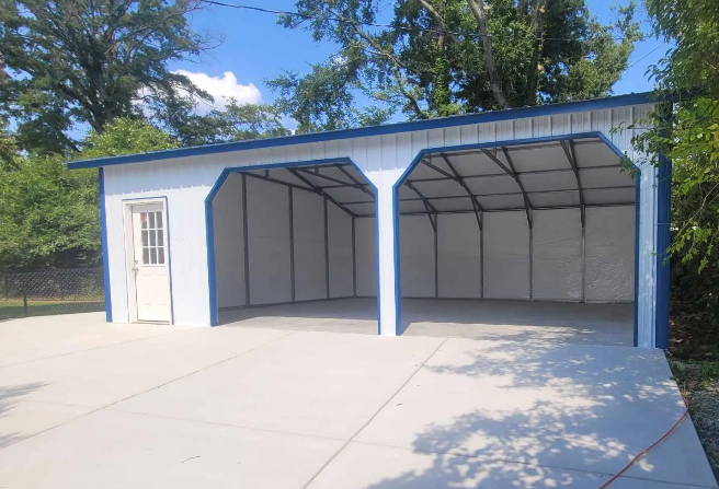 Two-bay white garage with blue trim, concrete floor, and a side door, outdoors on a sunny day.