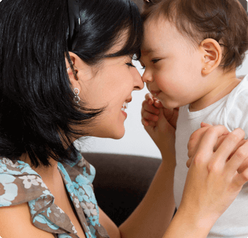 A woman and a baby are touching noses and smiling