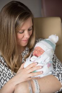 A woman is holding a newborn baby in her arms.