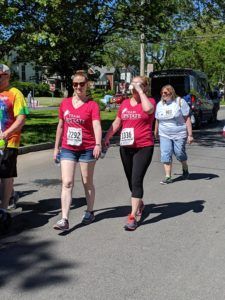 A group of people are walking down a street holding hands.